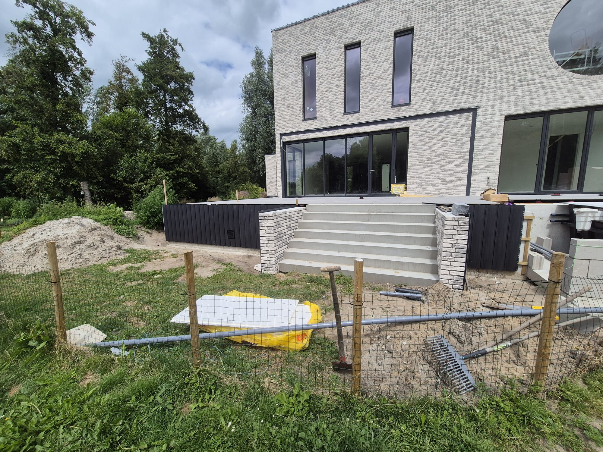 Lichte steenstripgevel met terras en trap