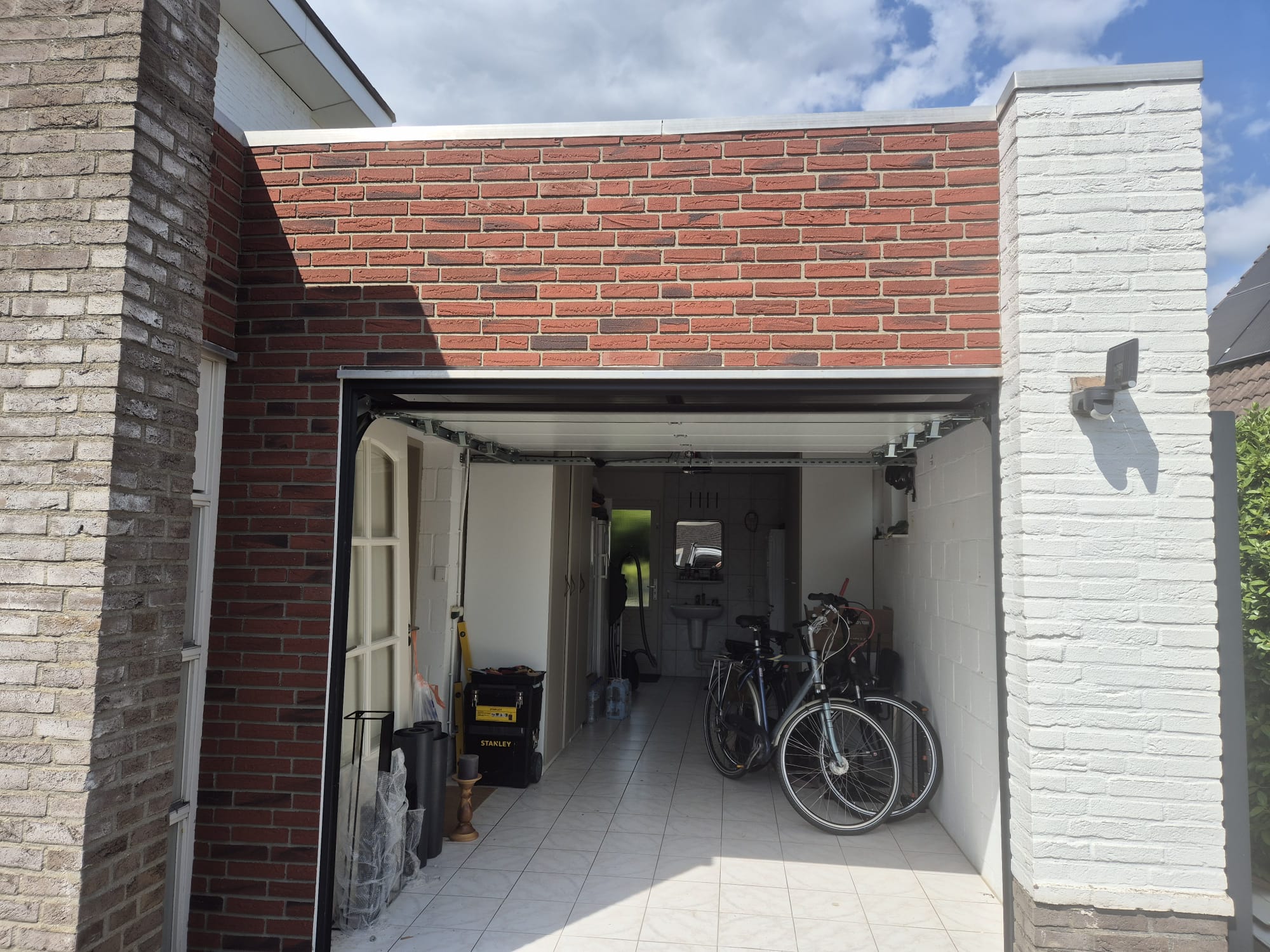 Rode steenstrips boven een open garage