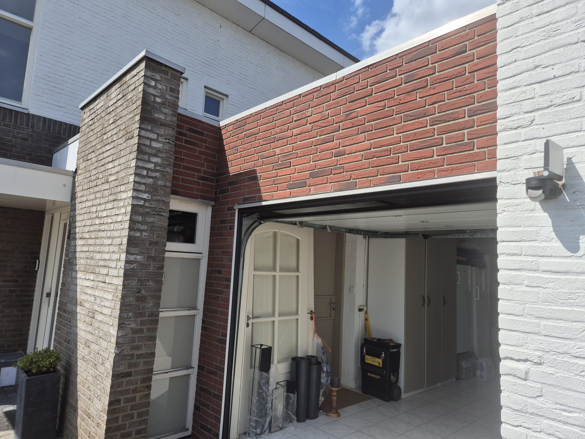 Detail van rode steenstrips boven een garage
